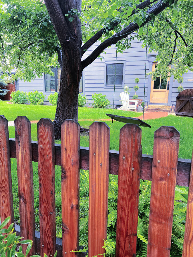 Wet front yard fence looking at swing and front door