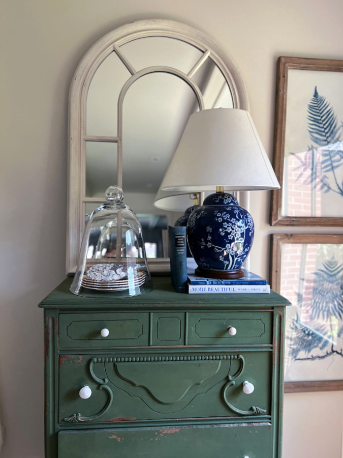 Green dresser with a glass cloche for deocr