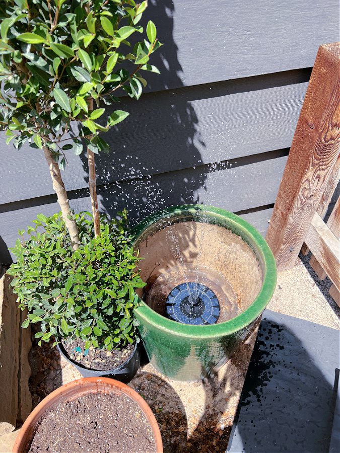 Solar fountain in green planter