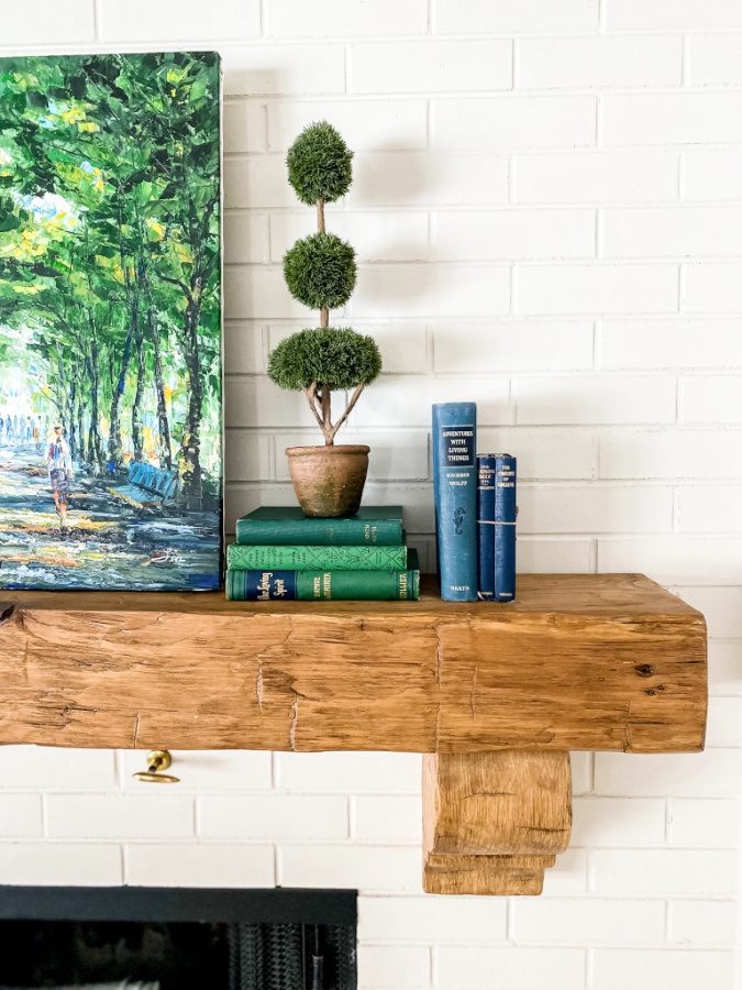 Blue and green books, topiaries, and painting make for beautiful Spring decor on your mantel.