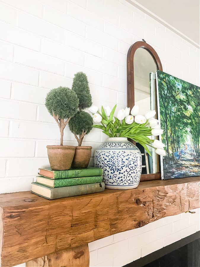 A rustic wood mantel mixed with classic styled blue, whites and green decor pop for Spring.