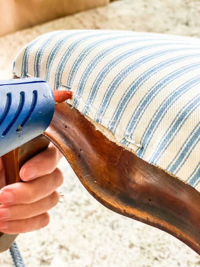 When recovering your footstool use a hot glue gun to secure your trim and hide the ugly staples.