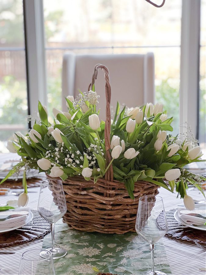 Flower arrangement in a basket: tulips and greenery