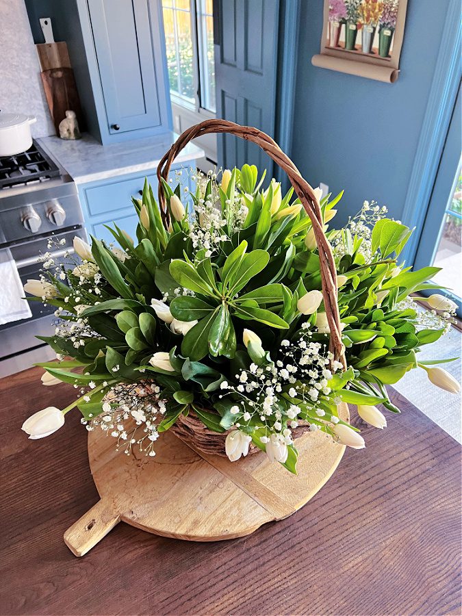 A pretty green and white flower arrangement in a basket!