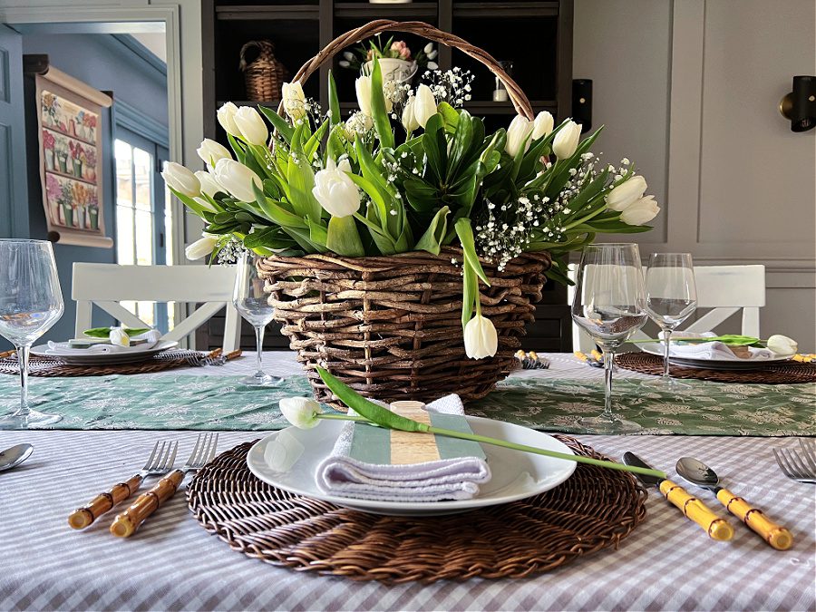 Spring table with white tulip flowers in a basket.