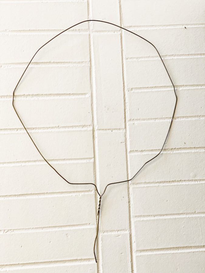 bend your metal hanger into a round shape for your ivy topiary.