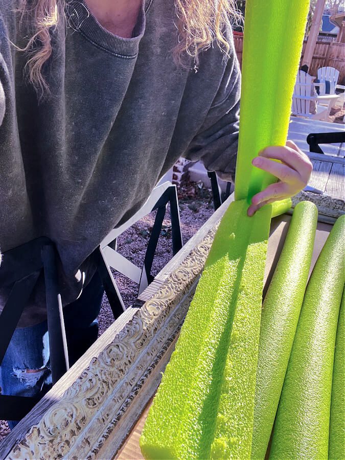 Ripping pool noodles so they attach to cardboard flat and even.