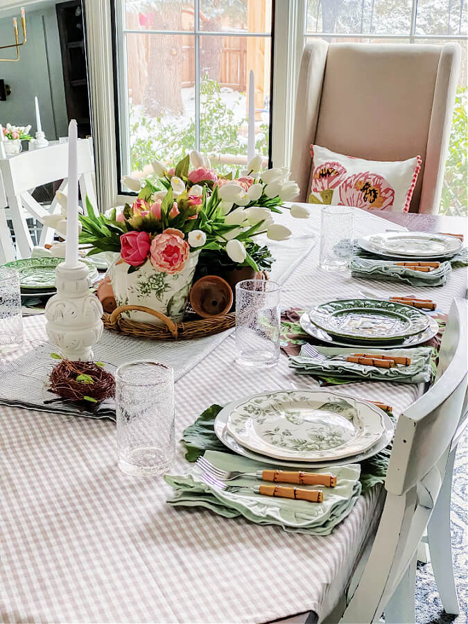 Mixing and matching plates on an Easter table with faux flowers.