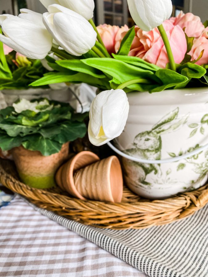 Easter table decor: mini pots, cabbage, faux flowers and bunnies.