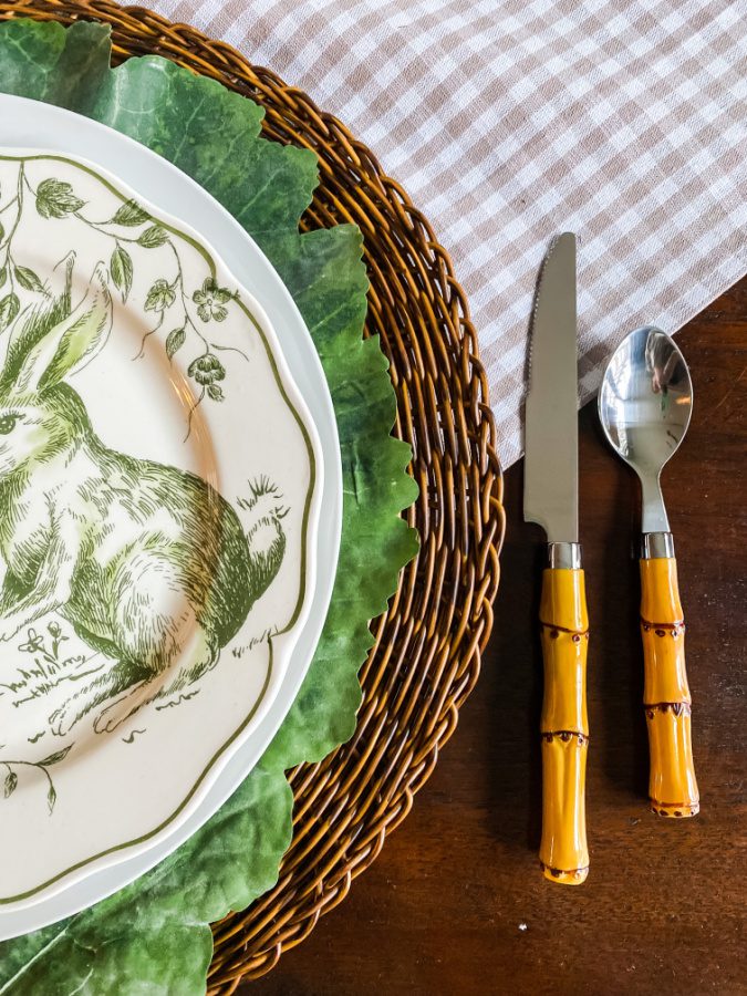 Faux bamboo flatware, green and white plates and wicker charges for an Easter table of layers.