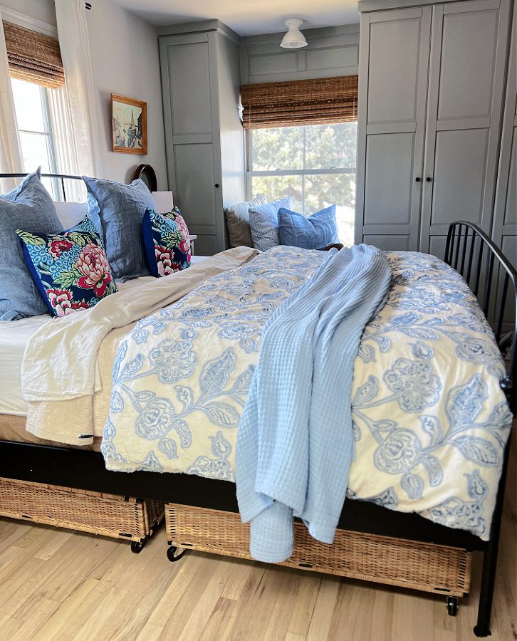 A side view of our bedroom with blues and white and rattan accents.