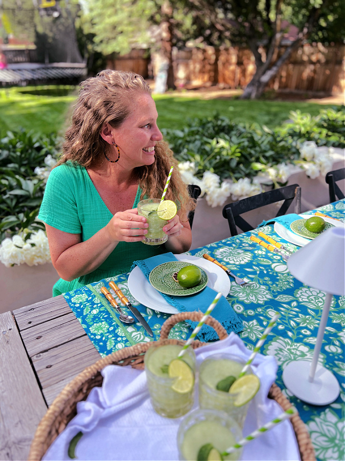 Me, Kelly in a green dress sitting outside drinking a frozen mojito