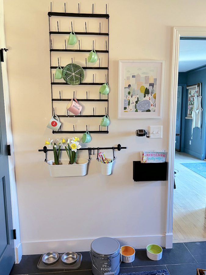 Mug rack on wall decorated with green jadeite cups for Spring tour  and a peek back into the kitchen.