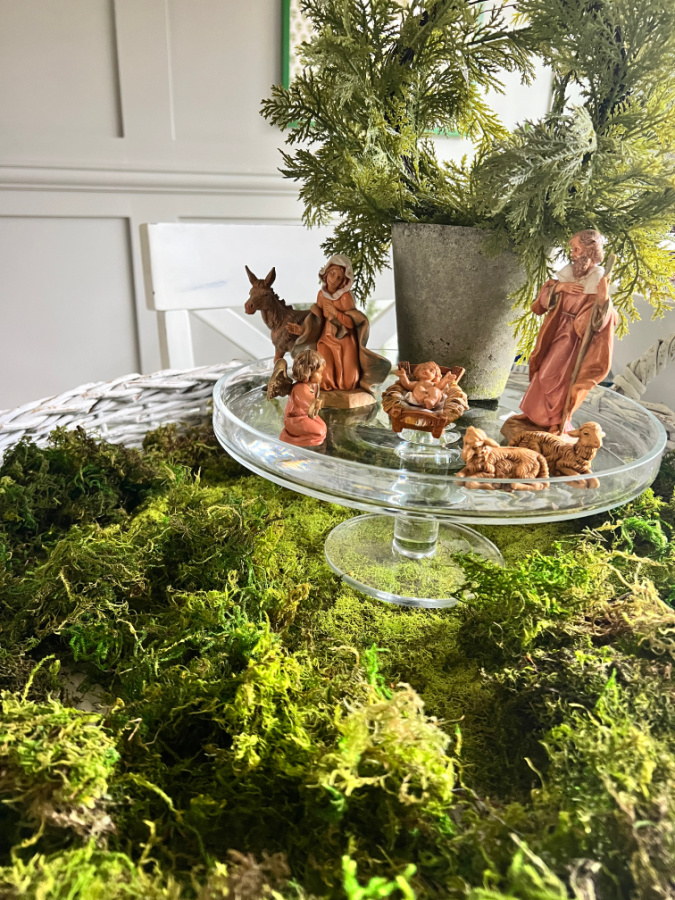 Nativity set on clear cake stand on moss