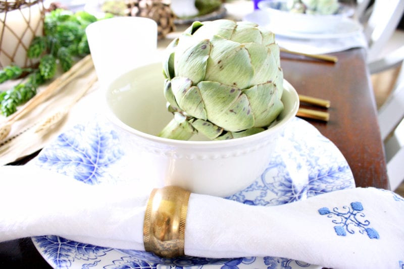 An artichoke brings an element of green to this neutral Autumn table.