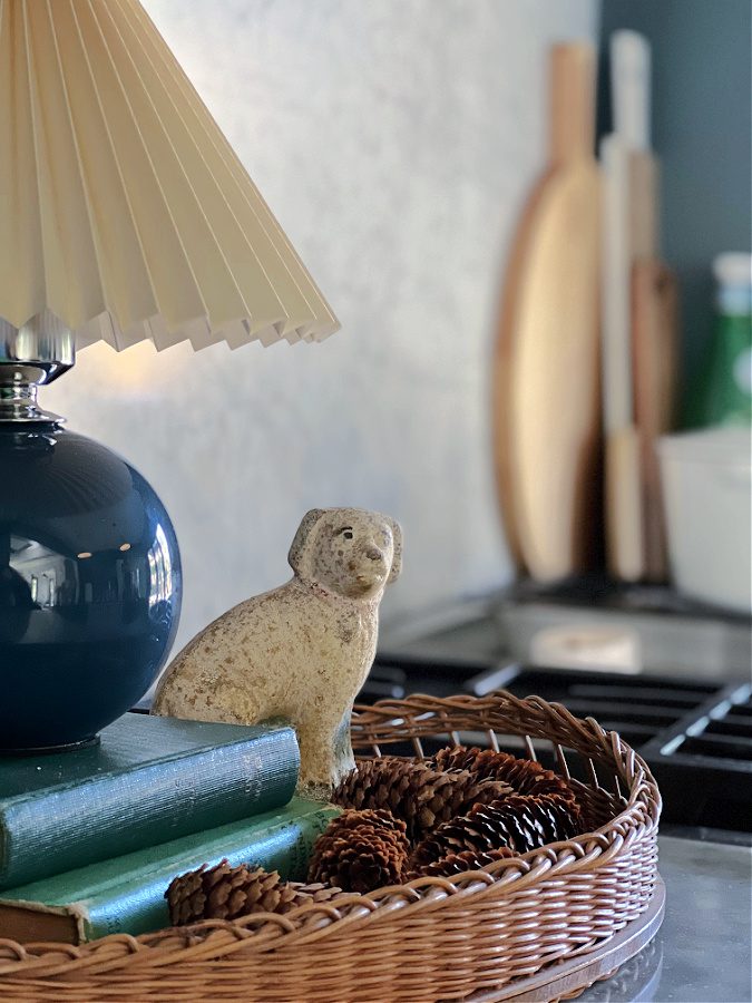 Fall vignetter with lamp, books, rattan tray and dog figurine