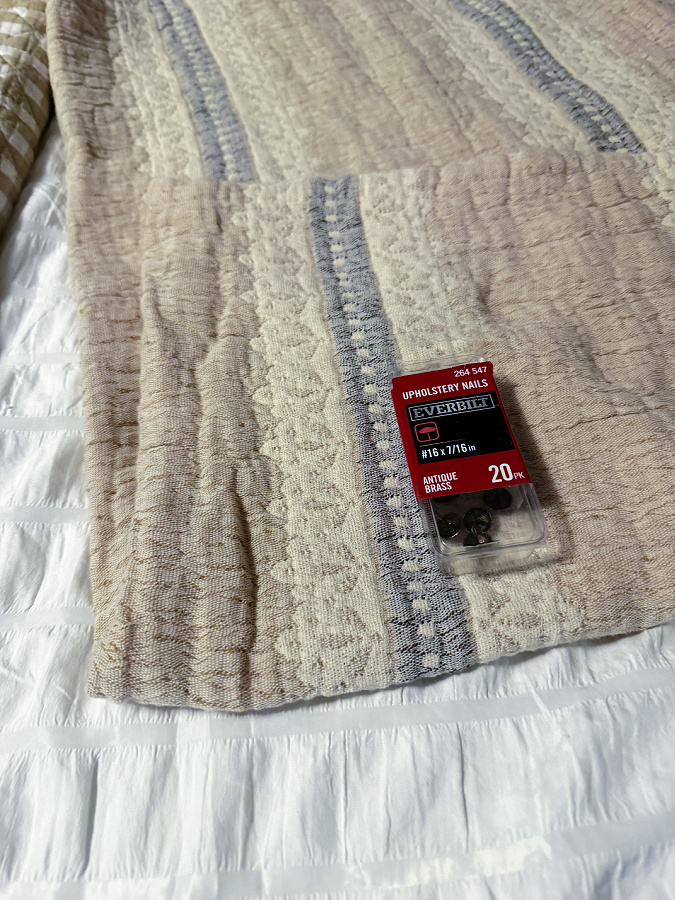 neutral blanket hung with upholstery tacks