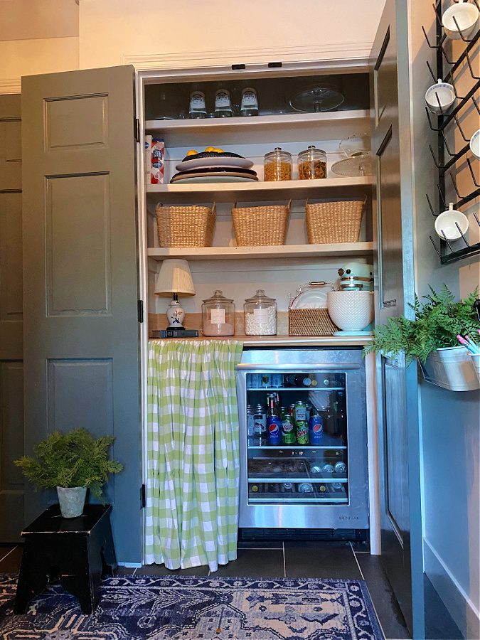 Green and white pantry skirt used to hide drink fridge.