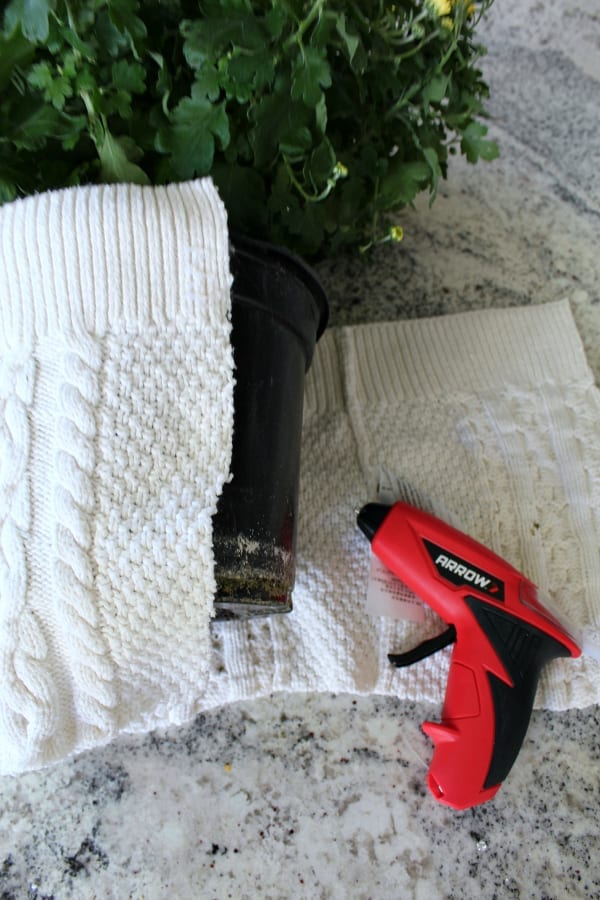 Simply use your hot glue gun to attach your sweater together and create your flower pot cover!