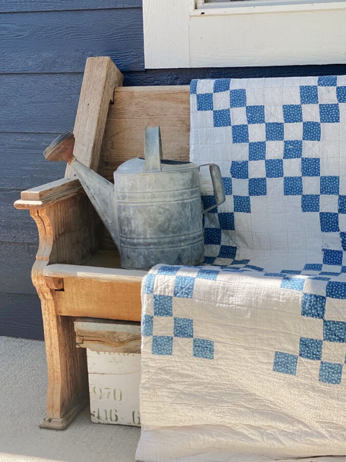 A blue and white vintage quilt on our summer porch