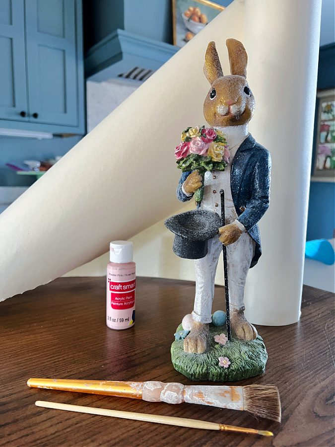 Supplies needed for painting and Easter Bunny Figurine. Paint, brushes, bunny and craft paper.