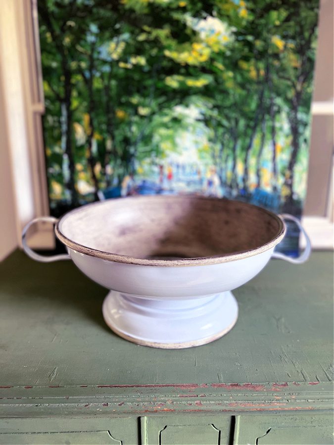 Pedestal bowl with handles on green dresser.