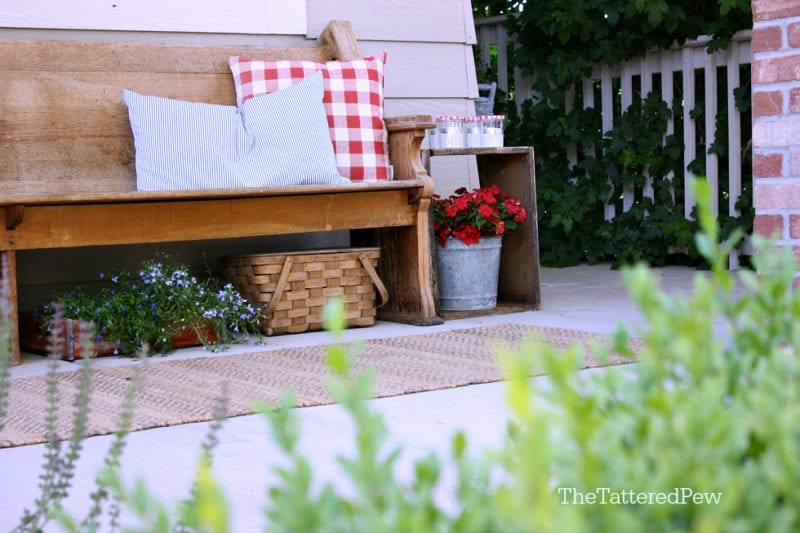 An old pew and touches of red, white & blue make this porch Summer ready!