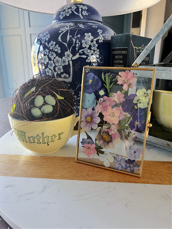 A counter top vignette with a pressed flower framed gift.