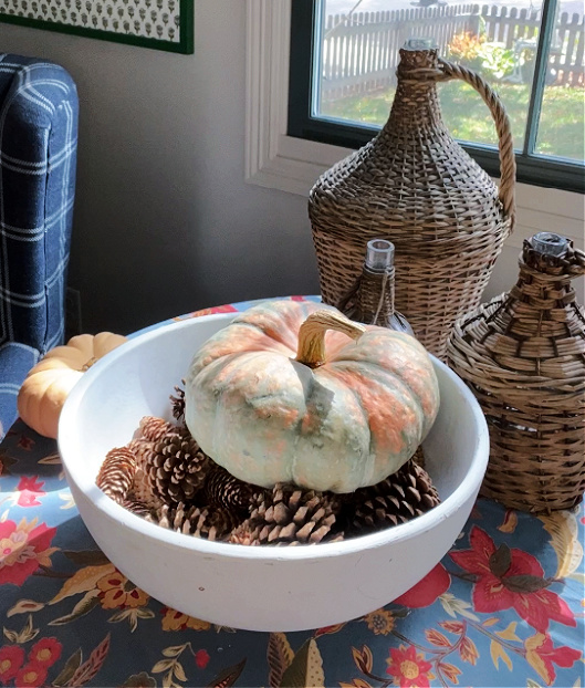 orange and green pumpkin on pinecones creates focal point of centerpiece