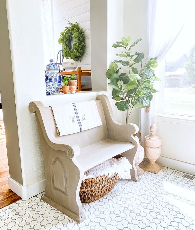 Welcome Home Saturday: How To Seamlessly Mix VIntage, Thrifted & New Decor In Your Home | Welcome Home Saturday by popular Alabama lifestyle blog, She Gave It A Go: image of a vintage light wood entryway bench with a with basket filled with white throw blankets underneath. 