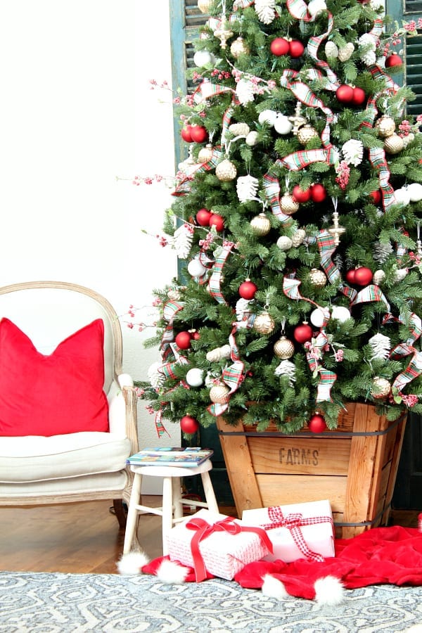 A red, white and plaid Christmas tree in an old tree box gives that perfect cozy Christmas feel.