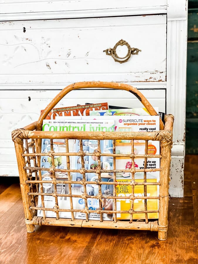 A vintage baboo magazine rack full of magazines.