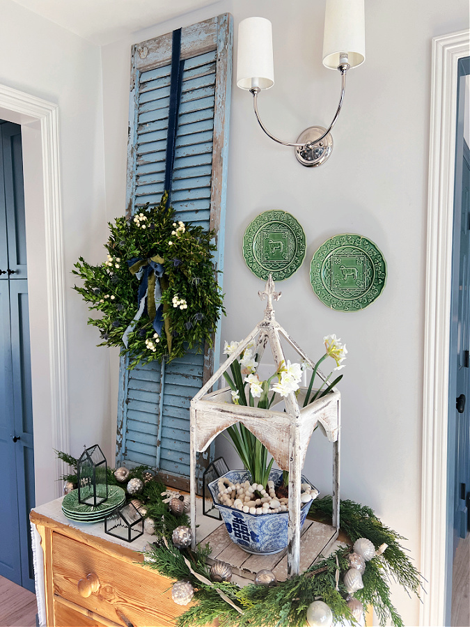 A Christmas corner with blues and greens, boxwood wreath on shutter