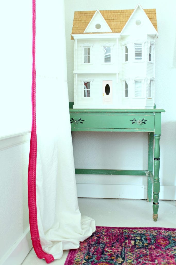 No sew drop cloth curtains with pink trim perfect for a playroom.
