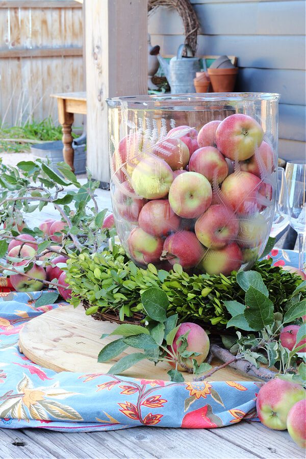 An apple centerpiece with a boxwood wreath.