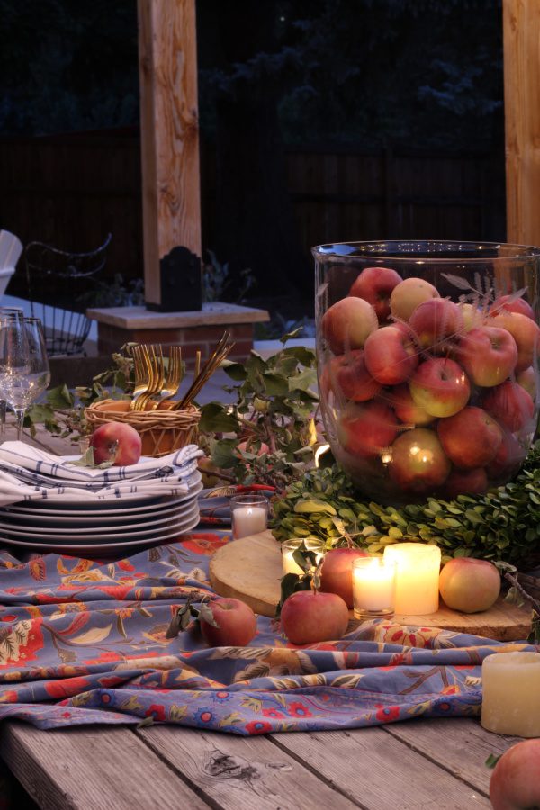Apples and candles make for the perfect outdoor Friendsgiving table setting.