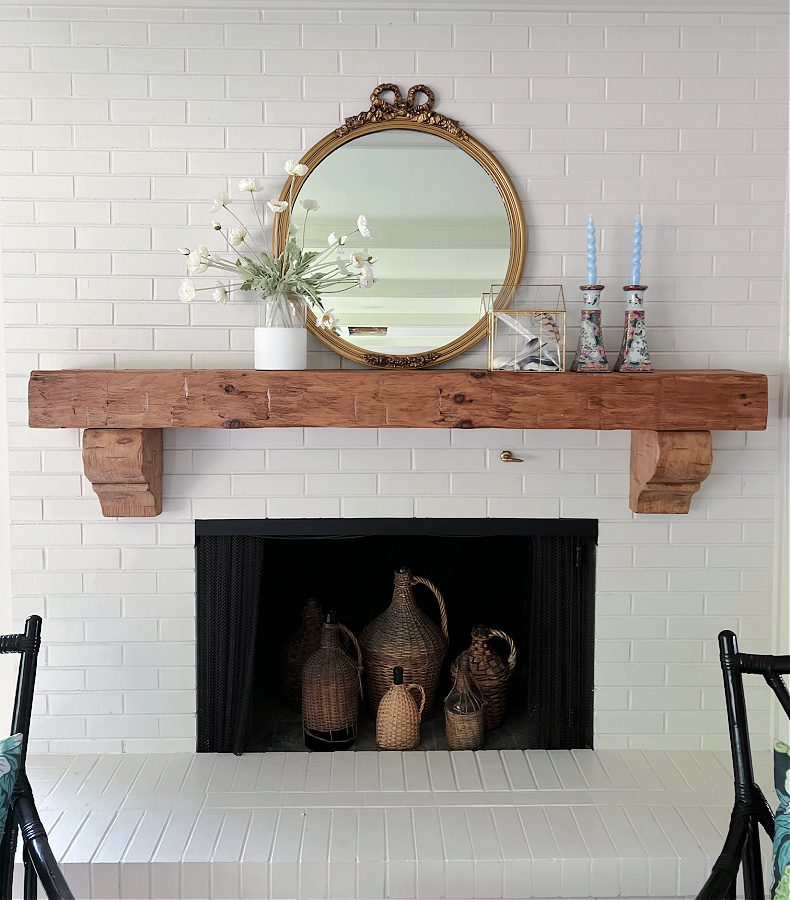 White brick fireplace, round mirror, minimal summer decor
