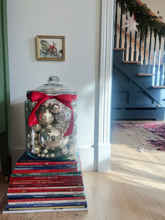 Christmas book stack with jar of vintage ornaments
