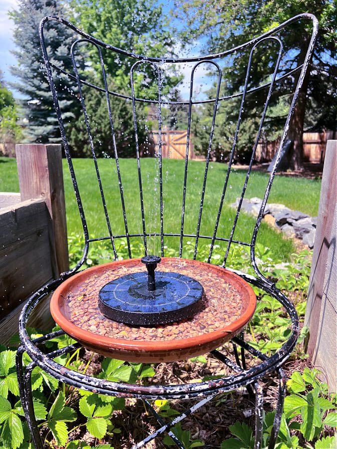 Solar fountain in terracotta saucer on chair