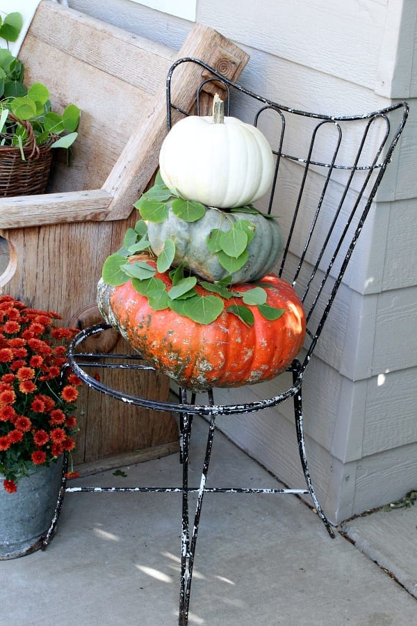 Stacked pumpkins on n old vintage chair.