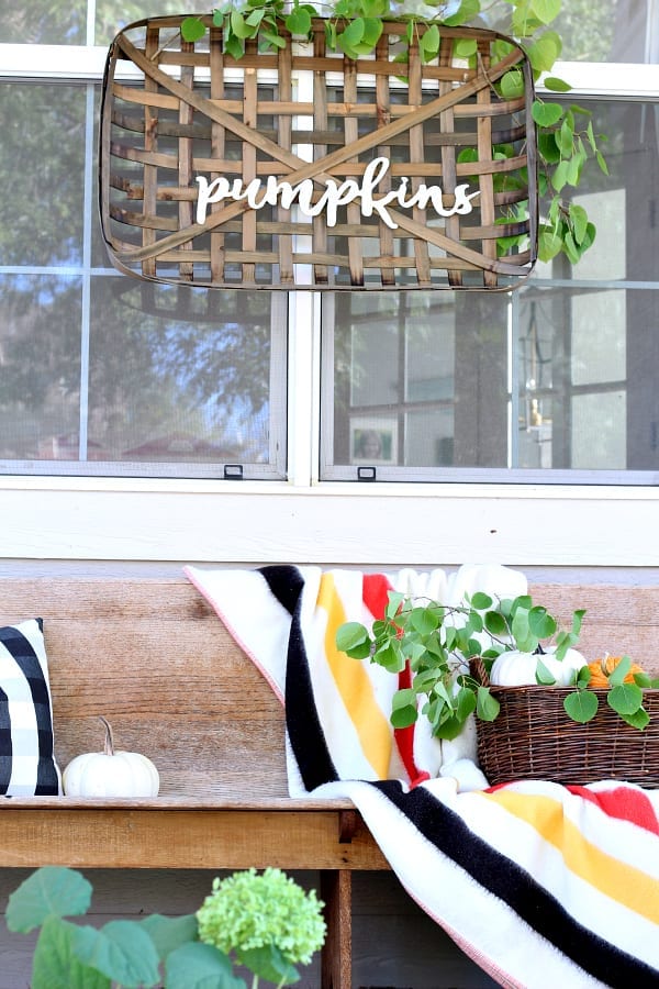 Pumpkins, basket and blankets are great ways to add vintage decor to your Fall porch.