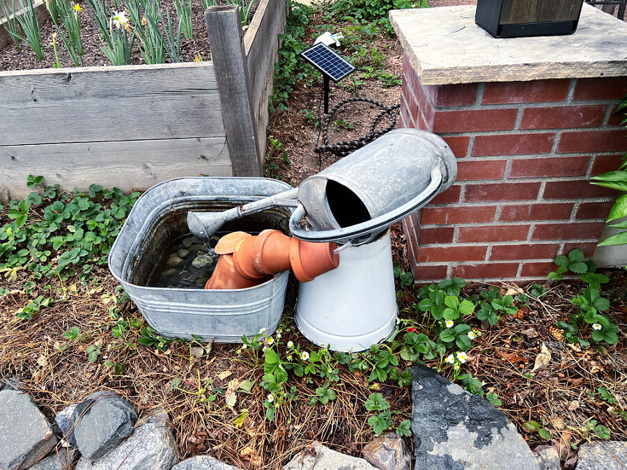 bucket propping watering can fountain