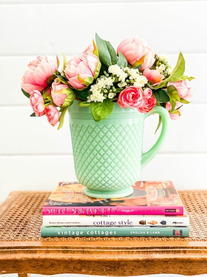 A bunch aof pretty faux flowers look perfect in this jadeite pitcher.