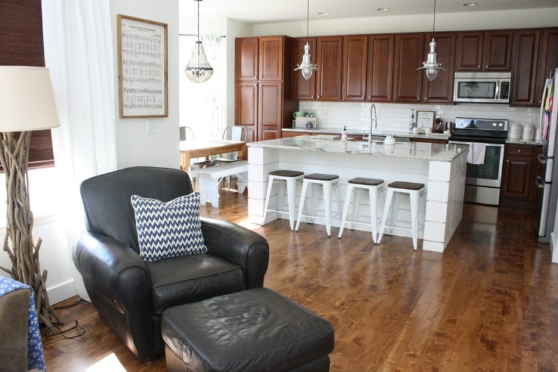 A kitchen with white island, wooden cabinets and white walls.