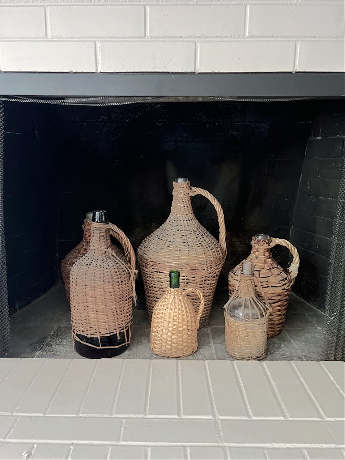 Wicker demi john bottles in the fireplace